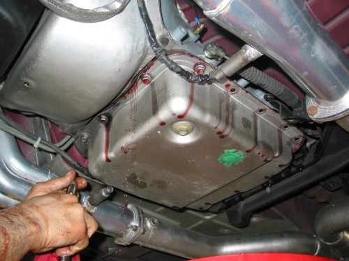 Once you have the seal broken between the pan and the gasket/transmission, carefully remove the rest of the bolts.