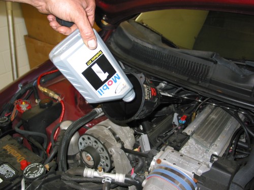 Add the necessary amount of Mobil 1 ATF fluid through the dipstick in the engine compartment.  A normal 4L60E in a Z28 would take around 4 to 5 qts just for a normal changout of the fluid.  It is important to remember here that much of the tranny fluid will stay in the torque converter and there is really no way to get it out when performing your own tranny fluid change so you'll be mixing your new ATF with the older ATF that was in there.  This is OK and it is even OK to mix synthetic and normal ATF if you decide to switch to Mobil 1 synthetic ATF.  In my case I am using a deep pan which takes about 2 qts more than a normal pan.  However, I also have a Vigilante 2800 converter which is slightly smaller than stock so for me, the total I needed to add was 5.5 qts :)