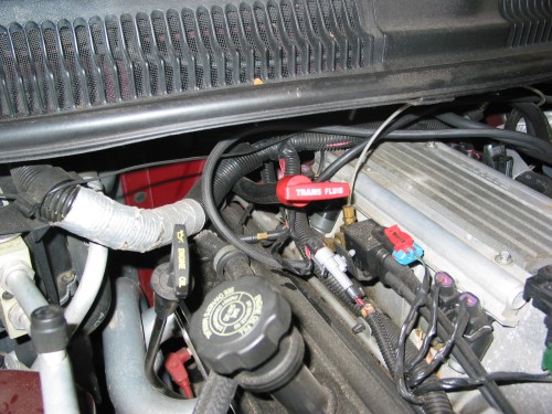 The Trans Fluid dipstick should be clearly labeled.  Make sure you aren't adding fluid to the Engine Oil dipstick area! :-)